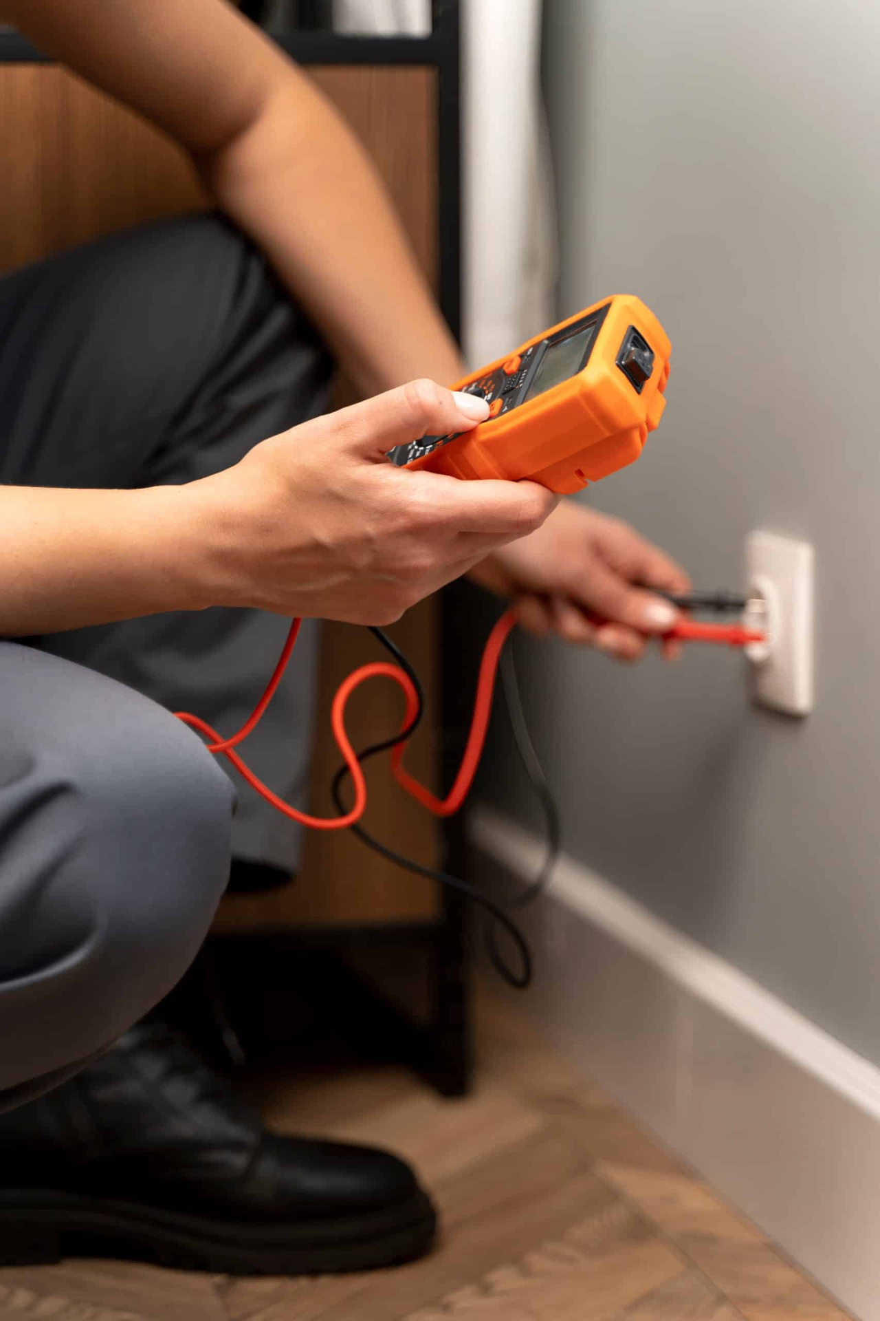 Électricien testant une prise résidentielle avec un multimètre